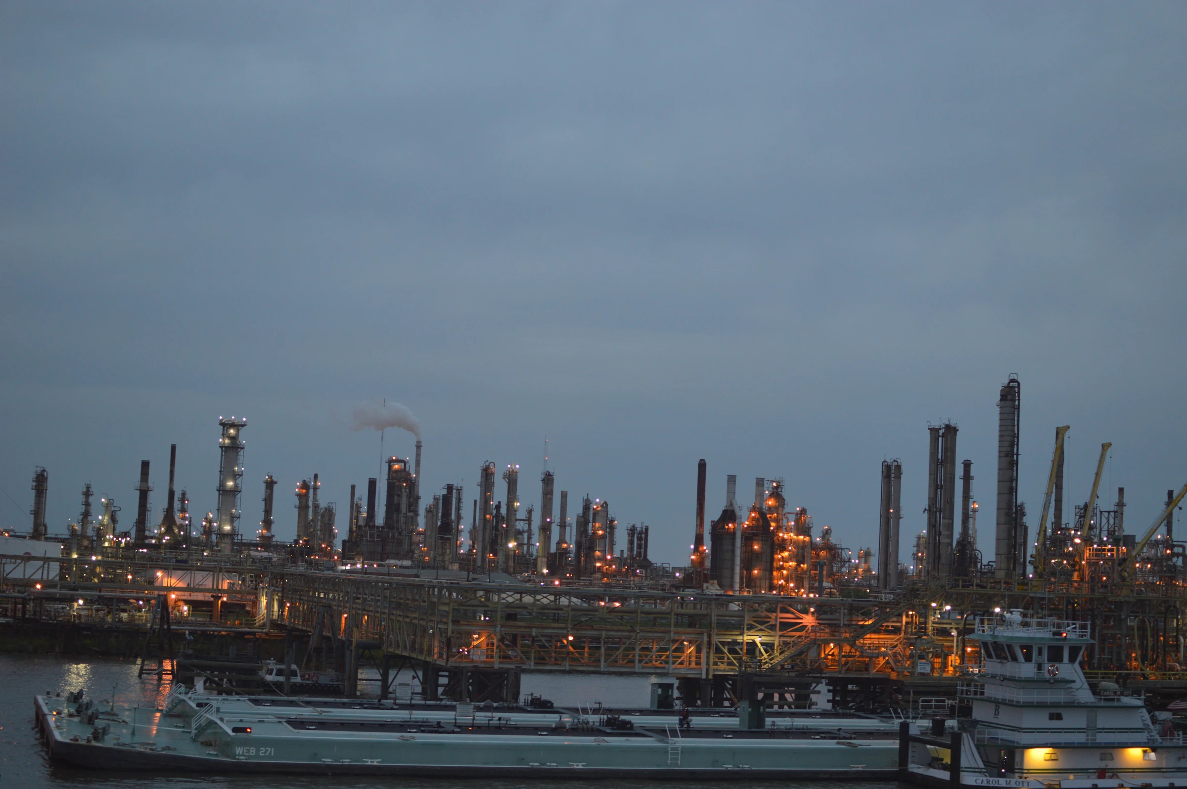 Complejo industrial junto a un puerto al anochecer